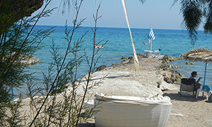 Bild von Strand, Meer und griechischer Fahne